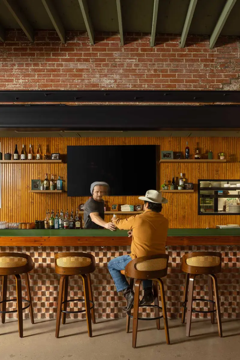 South BBQ bar with wood-paneled back bar, green counter and cane-back stools