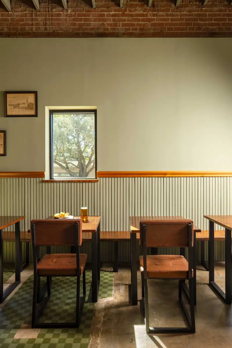 South BBQ dining room with wood wainscoting, green checkered floor and leather-seat chairs